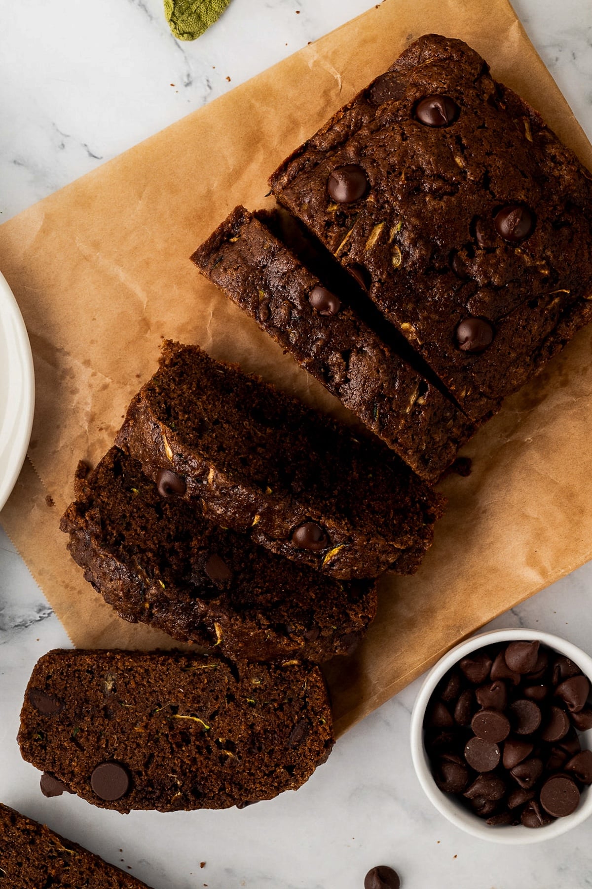 Sliced chocolate zucchini bread garnished with extra dark chocolate chips.