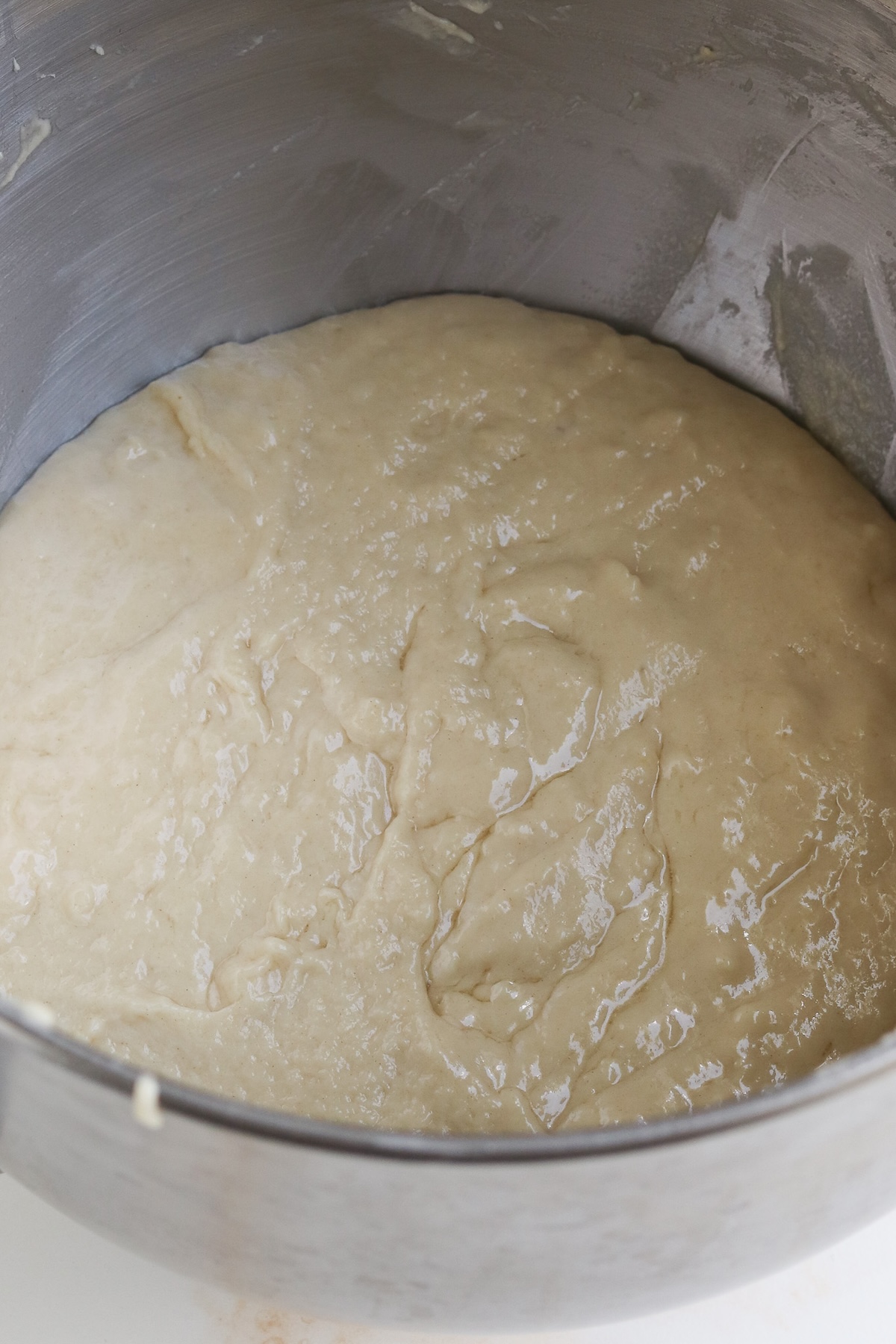 After adding butter to kolache dough in stand-mixer bowl it looks shiny on top, butter is incorporated into dough.