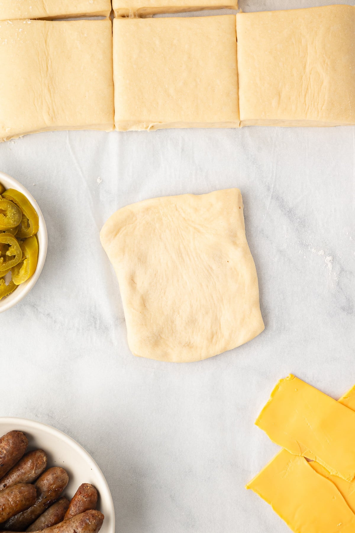 A individual square of dough pressed out to begin assembling kolaches.