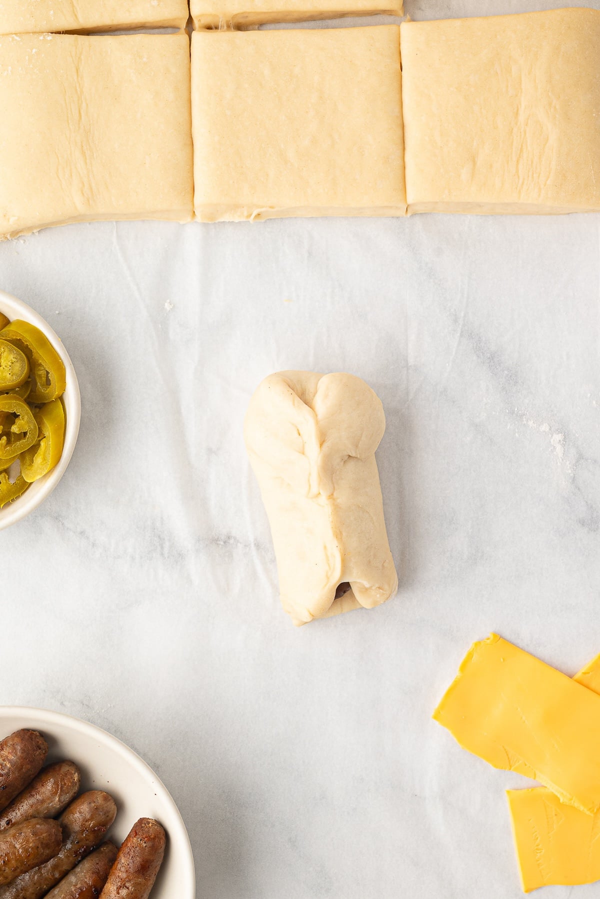 Wrapping the dough around the sausage.