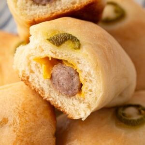 Closeup of the inside of a Texas jalapeno sausage cheese kolache showing melted cheese, breakfast sausage, soft pillowy bread, and jalapeno ring.